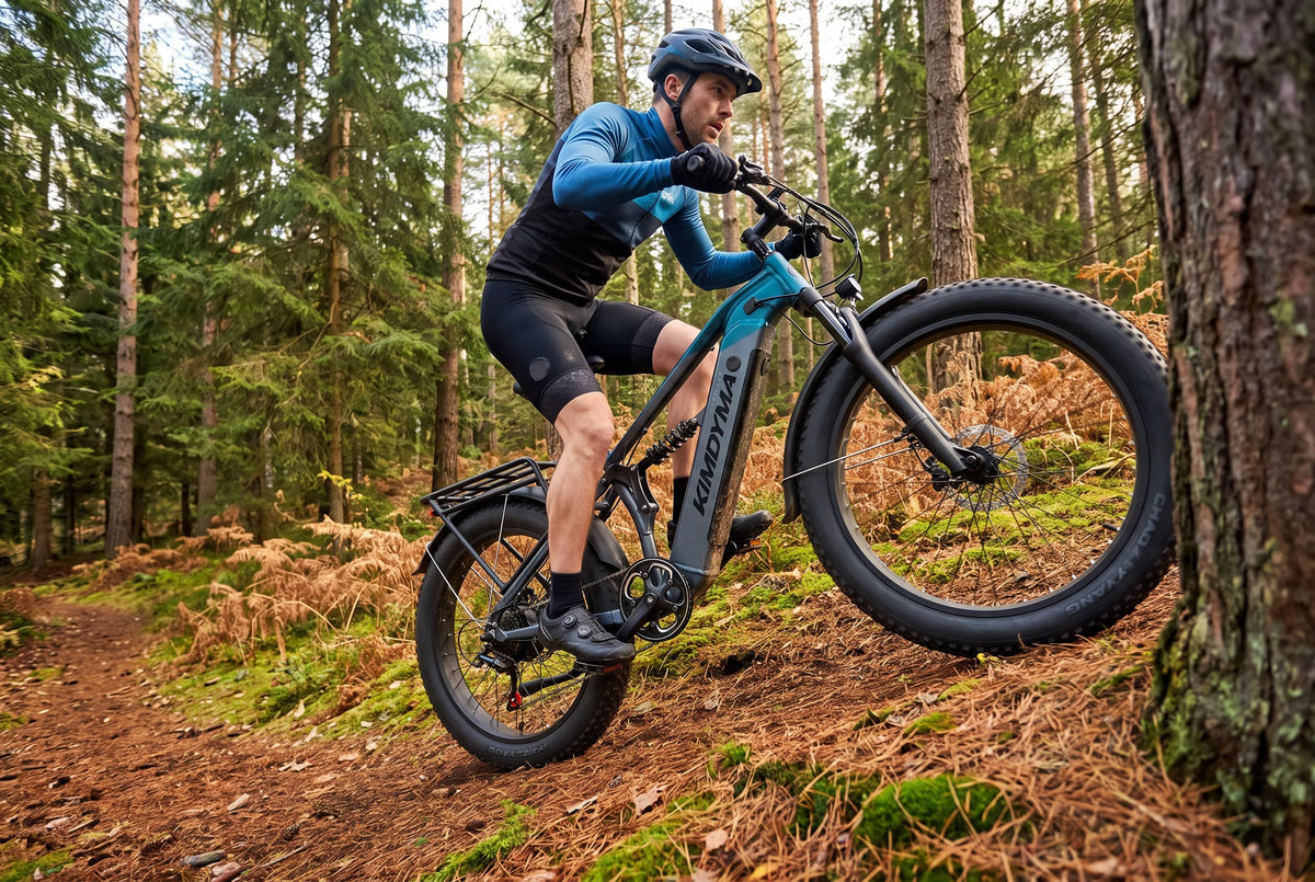 Ciclista subiendo por una pista forestal en una bicicleta eléctrica de montaña Kimdyma TITAN X