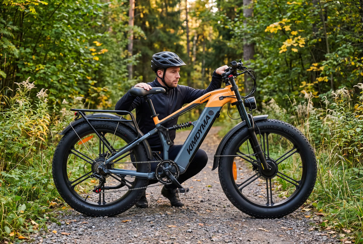 Bicicleta eléctrica de montaña aparcada sobre grava forestal mientras un ciclista comprueba la maneta del freno delantero antes de un descenso