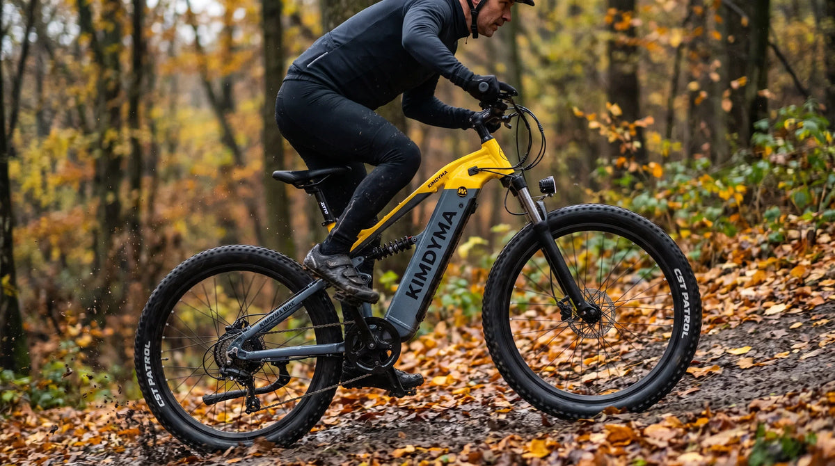 Ciclista de montaña subiendo por un sendero forestal en una bicicleta eléctrica con motor central y pantalla con sensor de par