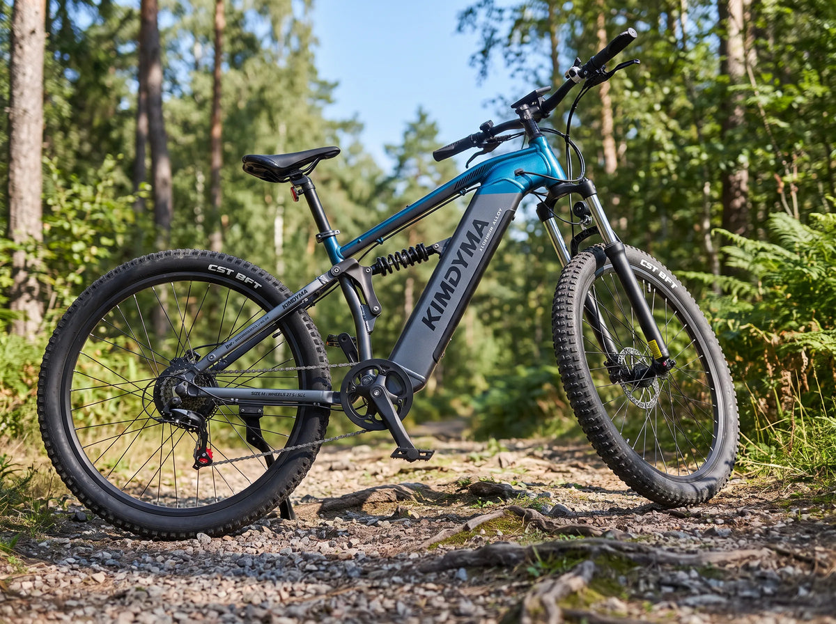 Mountain bike elettrica full-suspension Kimdyma M1 parcheggiata su un sentiero di ghiaia, ammortizzatore centrale visibile