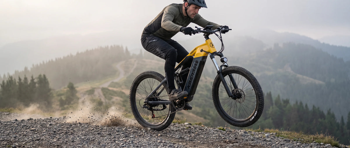 Bici elettrica Kimdyma M1 con un ciclista in volo su un sentiero forestale ghiaioso e pieno di radici, con la sospensione in funzione all'atterraggio.