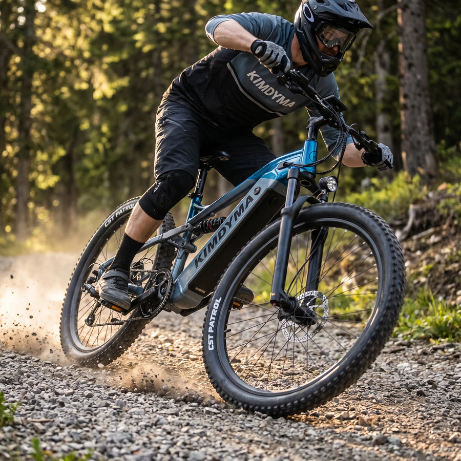 A Kimdyma K01 e-bike riding over rocky forest trail, front suspension fork compressing as the wheel crosses a stone obst