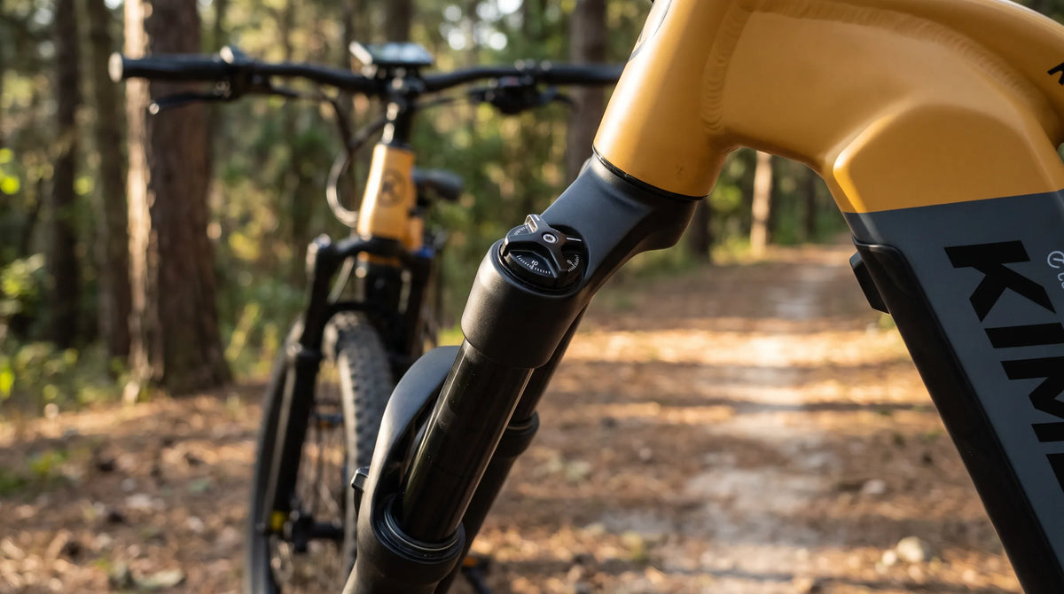 Nahaufnahme der Federgabel eines Kimdyma E-Mountainbikes mit hydraulischem Lockout-Mechanismus auf einem Waldweg