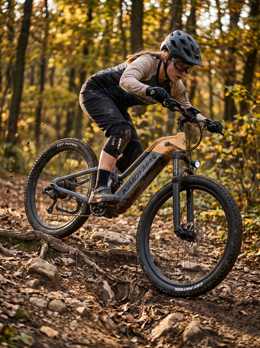 A young woman riding a Kimdyma K02 electric mountain bike downhill on a rugged forest trail covered with exposed roots,