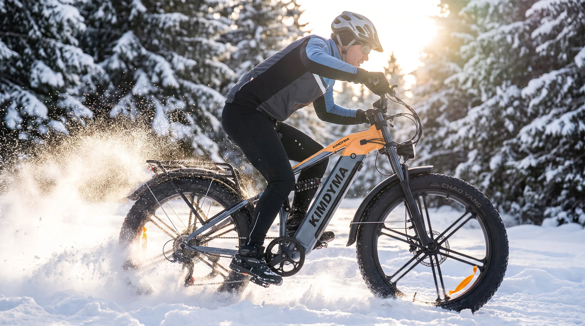 Ein Kimdyma K03 E-Mountainbike rast durch den Schnee und wirbelt weißen Pulverschnee in einer sonnigen Winterwaldlandschaft auf.
