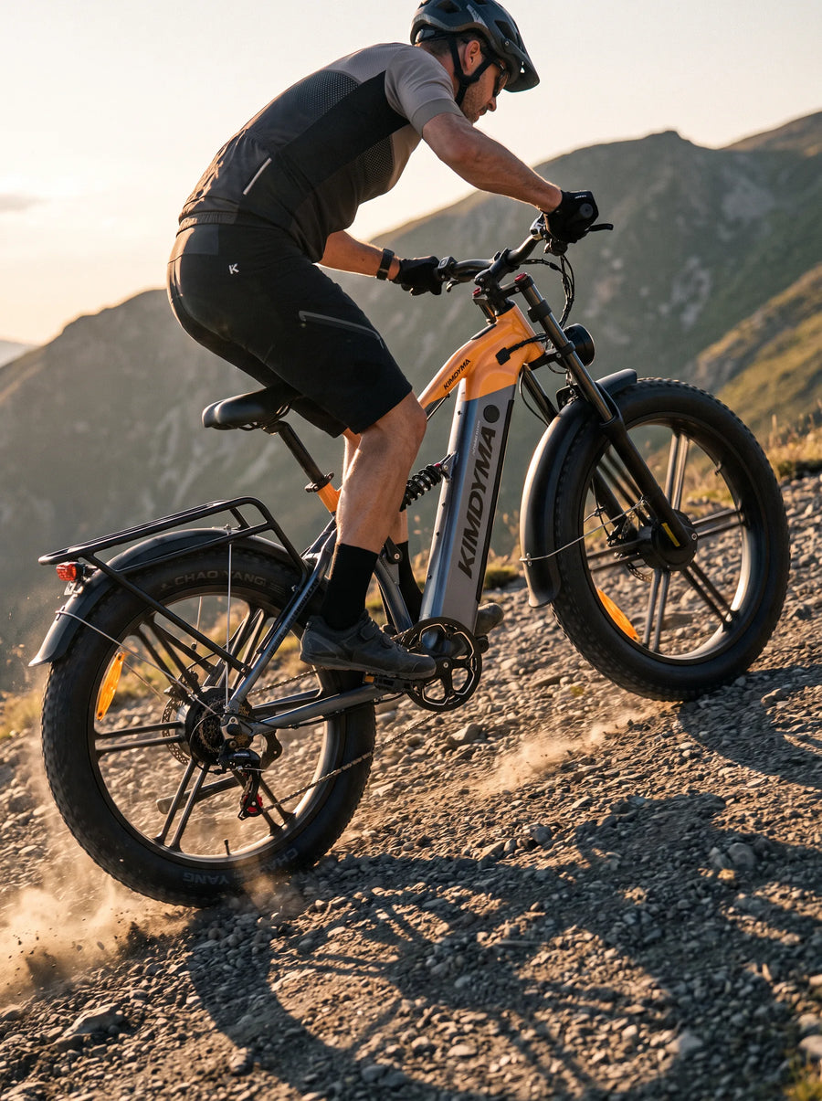 A Kimdyma K03 e-bike climbing a steep gravel mountain trail with loose rocks, shot from a low angle in morning sidelight